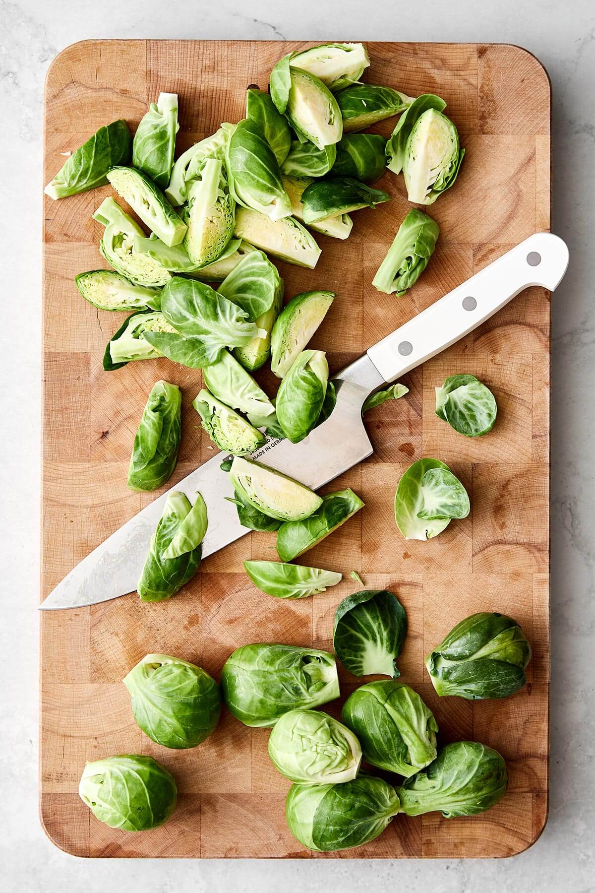 Chopped Brussels sprouts on a wooden board.