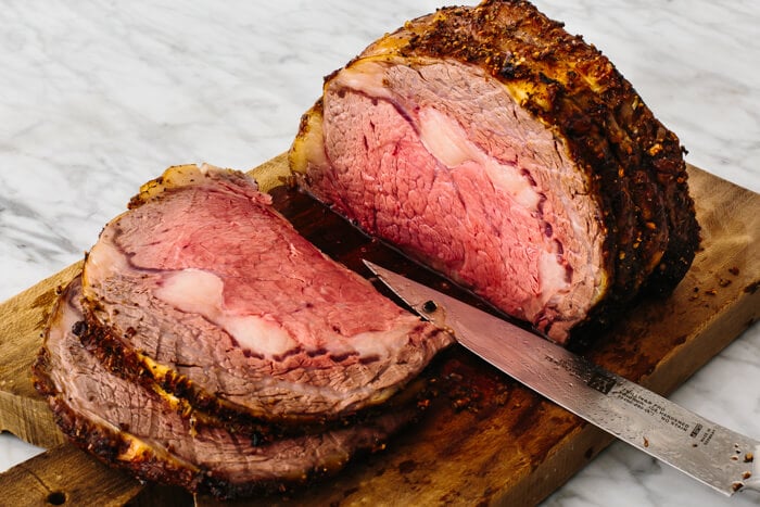 Sliced prime rib on a cutting board.