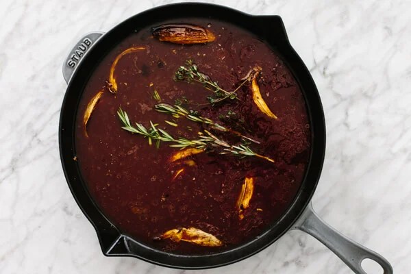 Making red wine au jus in a pan.