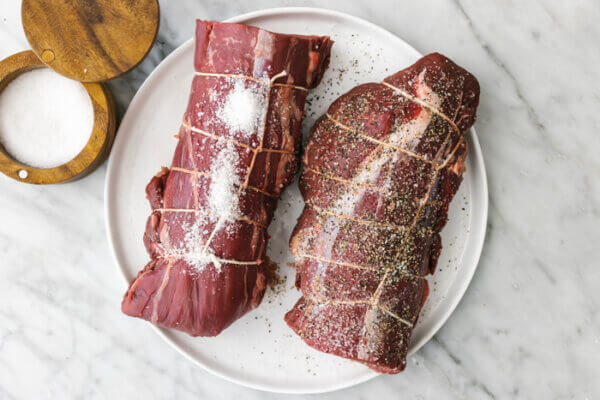 A plate of beef tenderloins seasoned with salt and pepper