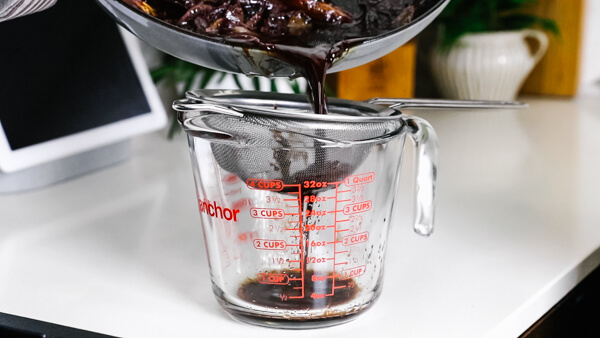 Straining the red wine au jus.