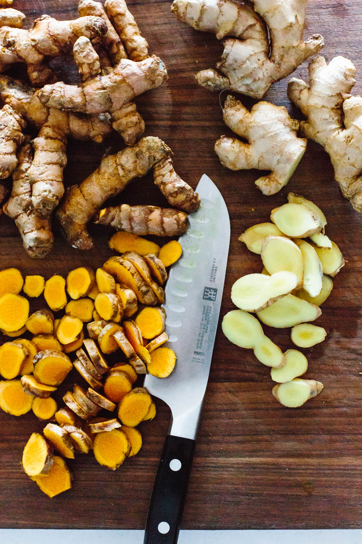 Turmeric and ginger chopped on a cutting board.