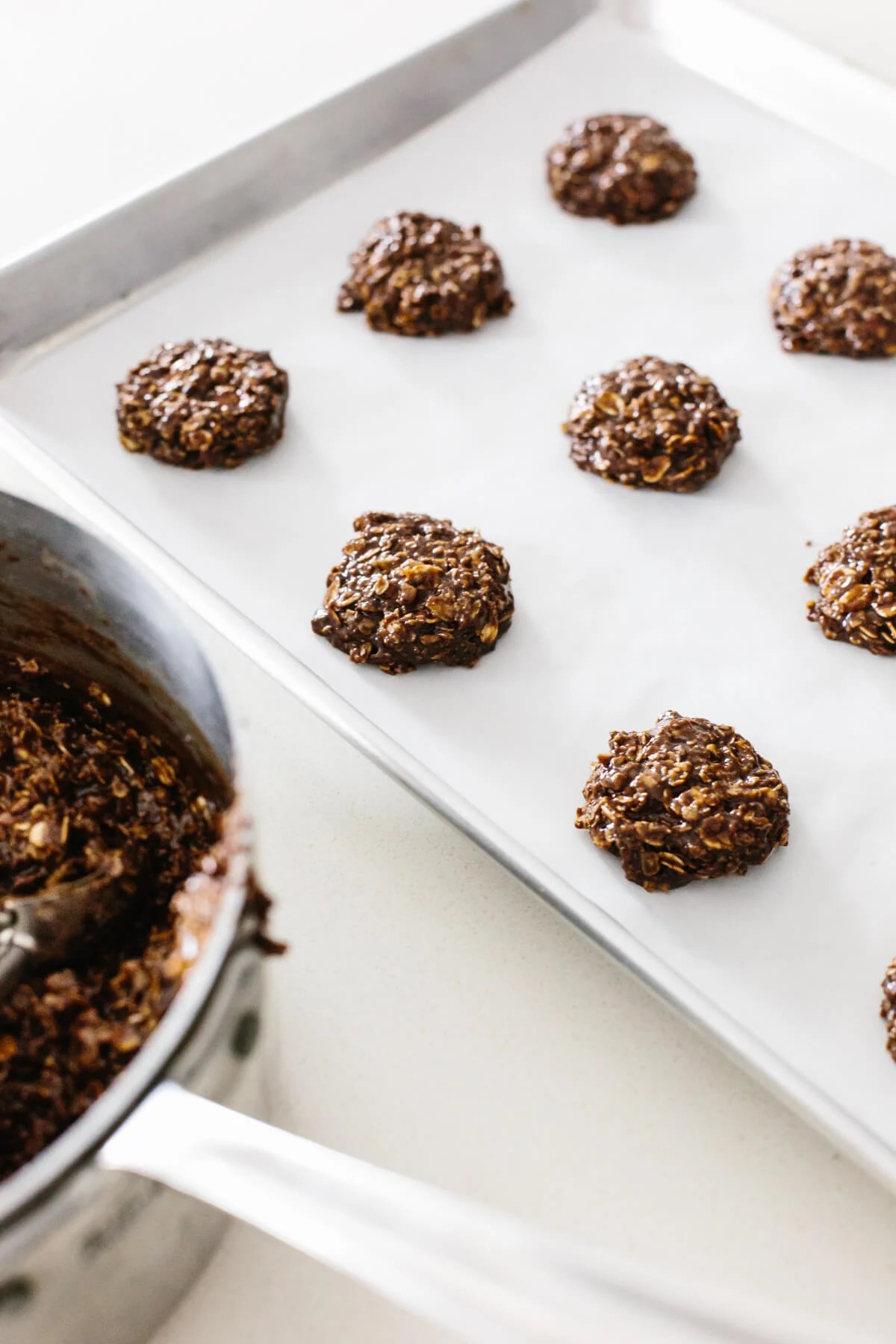Forming no bake cookies on a sheet pan.