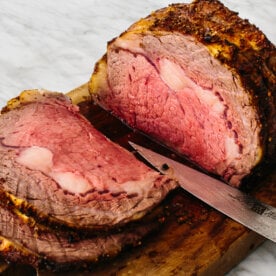 Prime rib sliced on a cutting board.