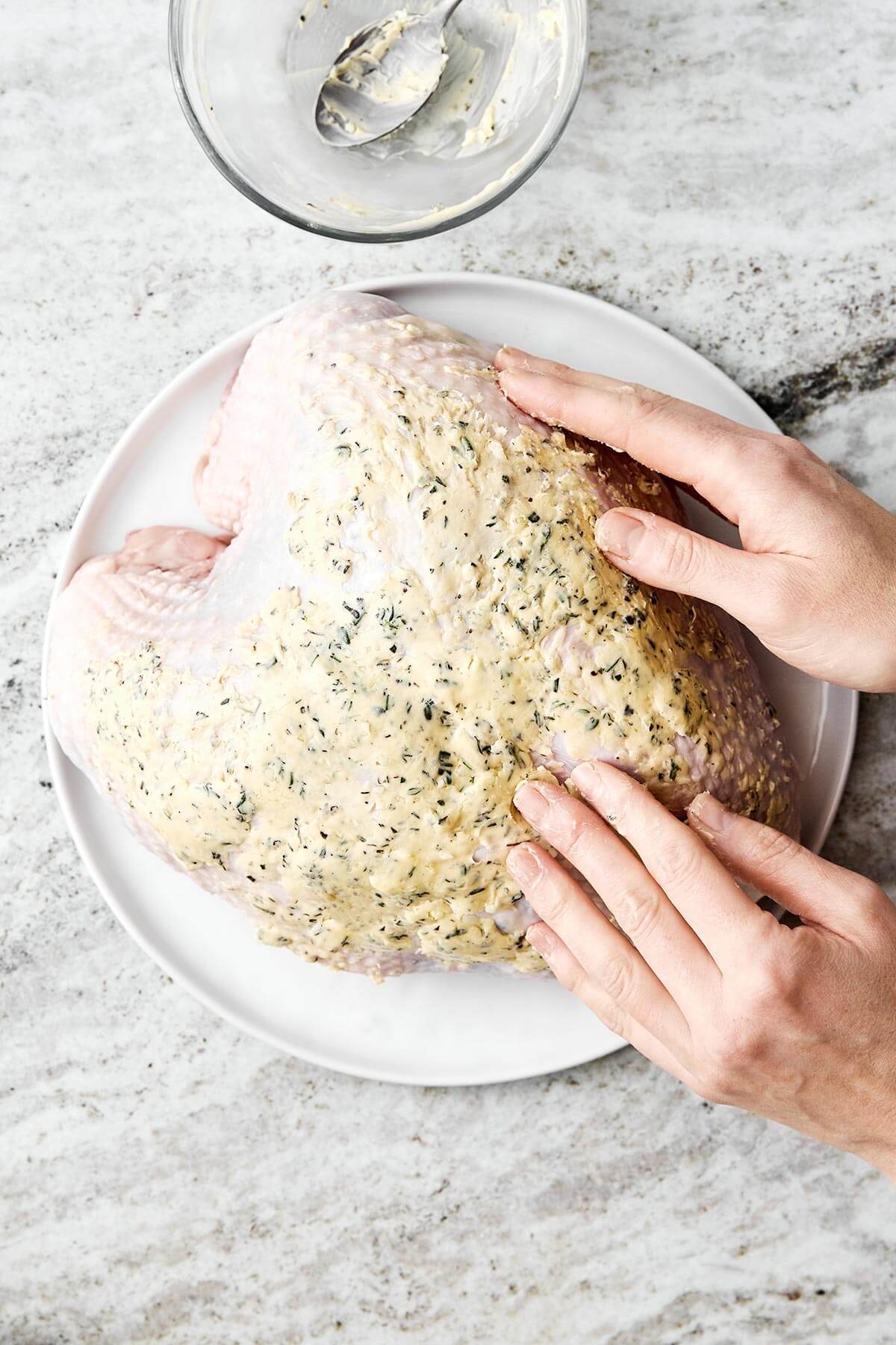 Adding butter onto a turkey breast.