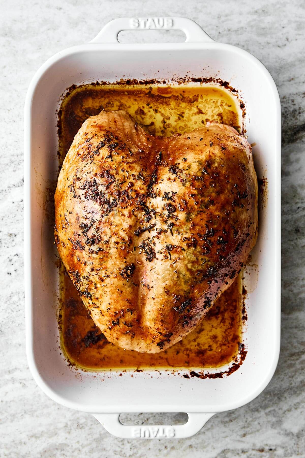 A roasted turkey breast in a baking dish.