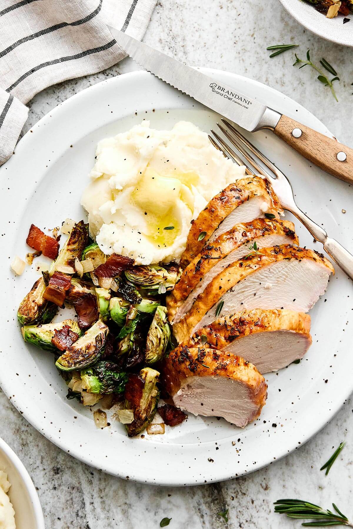 Roasted turkey breast on a plate with mashed potatoes.