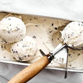 Vegan cacao nib ice cream with a scooper.